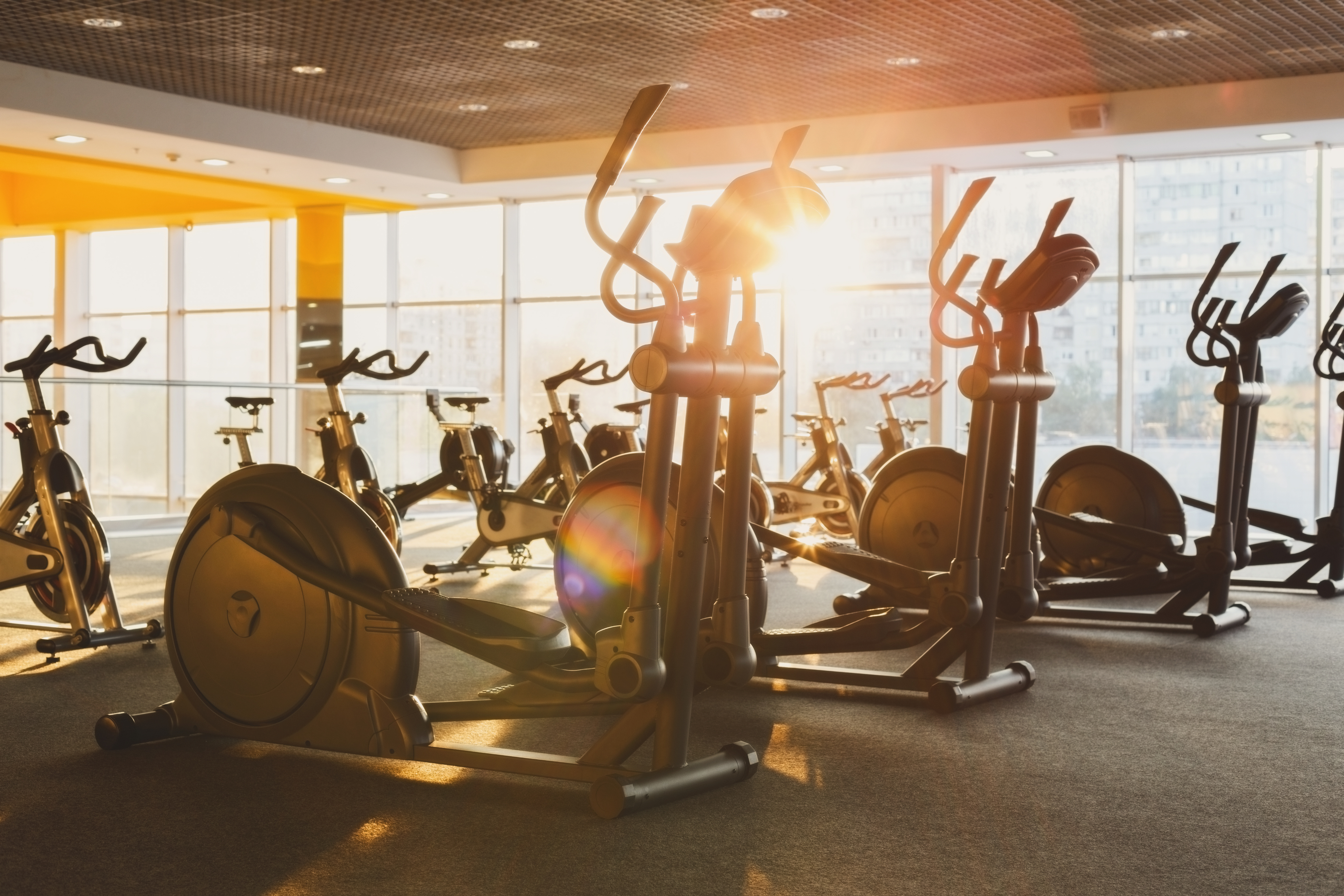 A Nashville gym filled with stationary bikes basks in sunlight streaming through large windows.