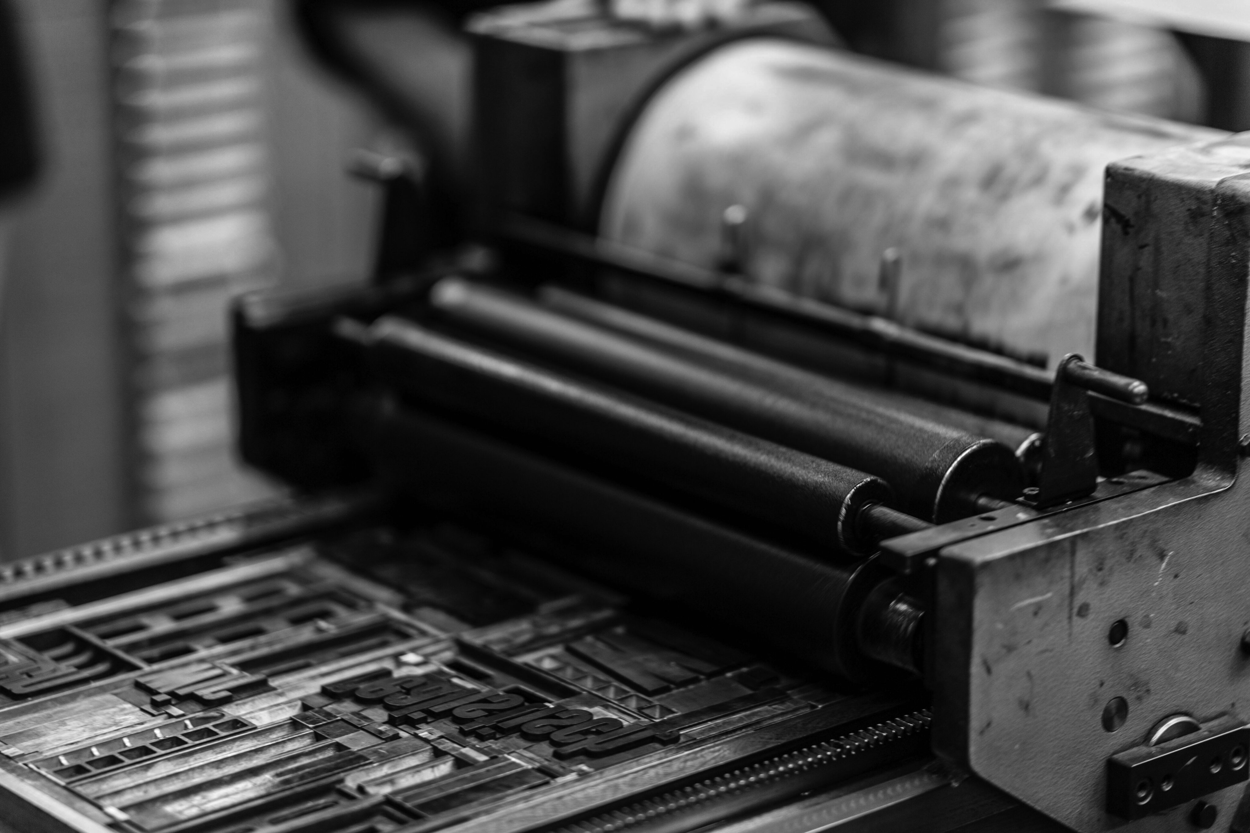 A black and white photo captures an old printing press in Nashville, its rollers and typeset letters standing as a testament to the city's rich history in publishing.