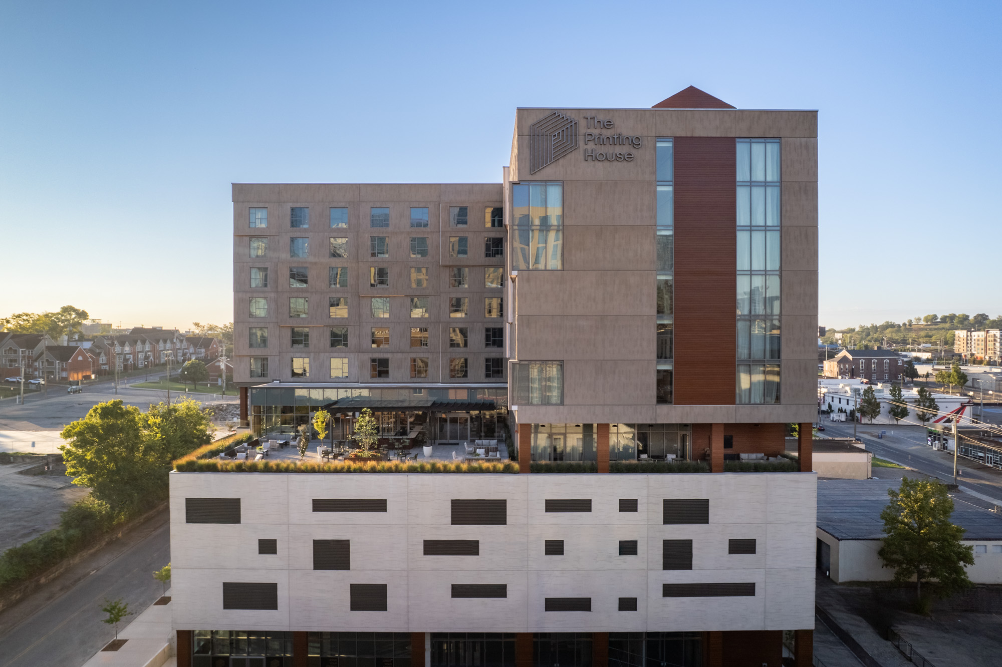 A modern multi-story building named The Printing House, featuring large windows and geometric design elements, under a clear sky.
